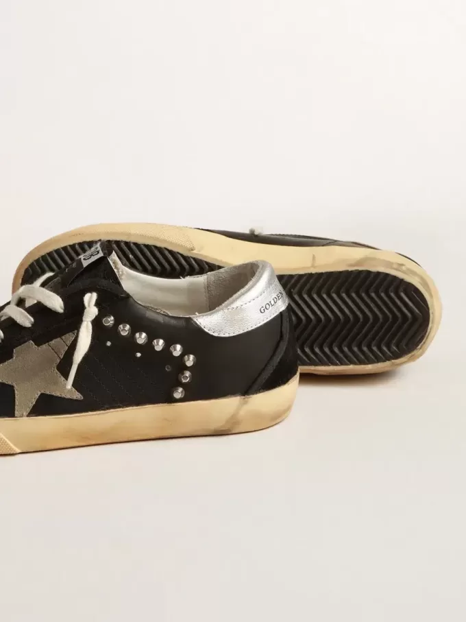 Superestrella femenina en cuero negro y ante con tachuelas plateadas Superestrella femenina en cuero negro y ante con tachuelas plateadas