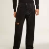 Vaqueros negros de hombre con corte holgado y cristales con efecto degradado en toda la prenda. Vaqueros negros de hombre con corte holgado y cristales con efecto degradado en toda la prenda.