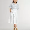 Vestido camisero para niña en lona de algodón blanca con estampado náutico azul y ribetes blancos Vestido camisero para niña en lona de algodón blanca con estampado náutico azul y ribetes blancos