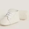 Zapatillas New Born en piel blanca con estrella perforada Zapatillas New Born en piel blanca con estrella perforada