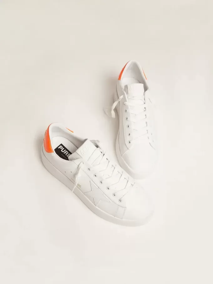 Zapatillas Purestar blancas con lengüeta naranja fluorescente en el talón