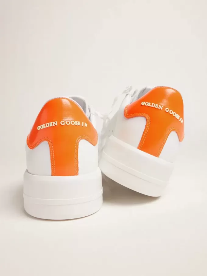 Zapatillas Purestar blancas con lengüeta naranja fluorescente en el talón