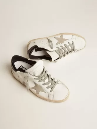 Zapatillas Super-Star para mujer con lengüeta negra en el talón y letras metálicas con tachuelas Zapatillas Super-Star para mujer con lengüeta negra en el talón y letras metálicas con tachuelas