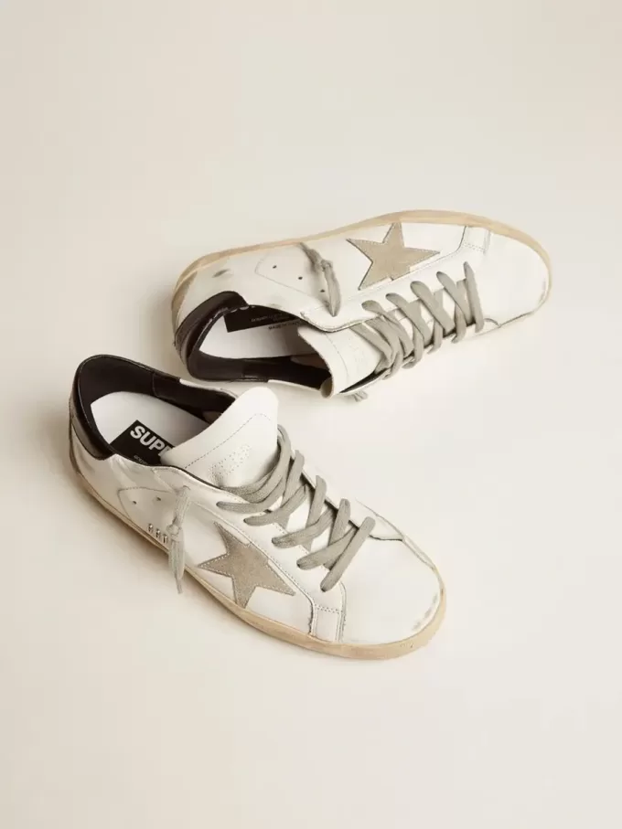 Zapatillas Super-Star para mujer con lengüeta negra en el talón y letras metálicas con tachuelas Zapatillas Super-Star para mujer con lengüeta negra en el talón y letras metálicas con tachuelas
