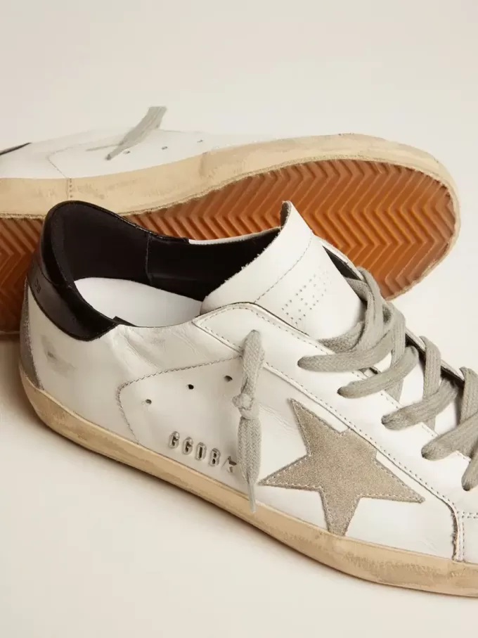 Zapatillas Super-Star para mujer con lengüeta negra en el talón y letras metálicas con tachuelas Zapatillas Super-Star para mujer con lengüeta negra en el talón y letras metálicas con tachuelas