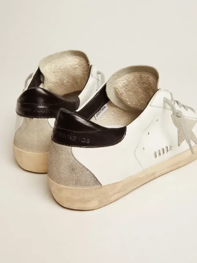 Zapatillas Super-Star para mujer con lengüeta negra en el talón y letras metálicas con tachuelas Zapatillas Super-Star para mujer con lengüeta negra en el talón y letras metálicas con tachuelas